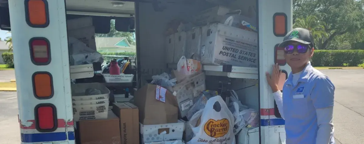 letter carrier with donated food for Stamp Out Hunger