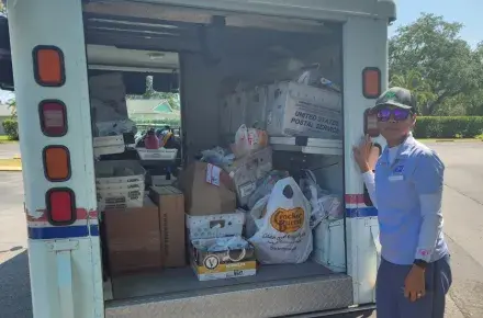 letter carrier with donated food for Stamp Out Hunger
