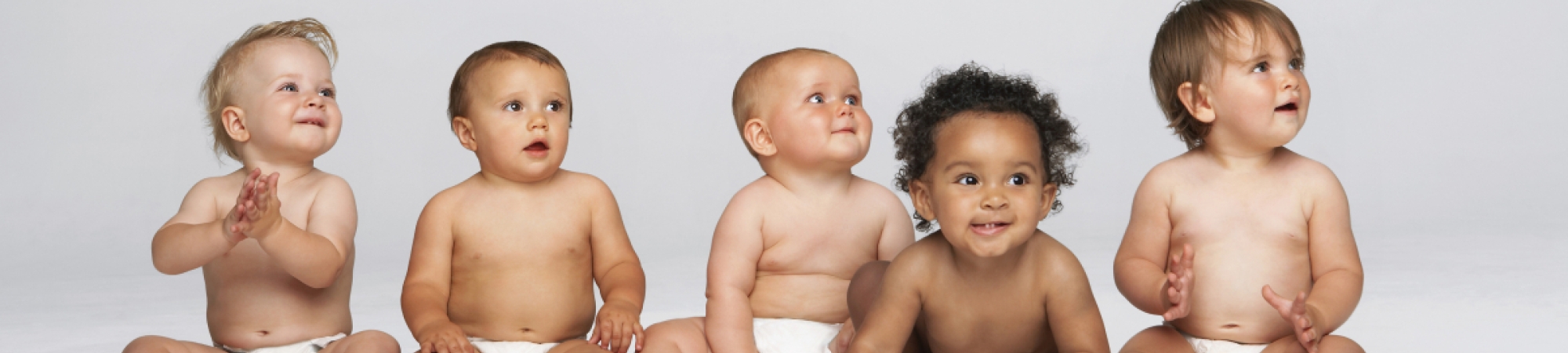 Babies sitting in a row in diapers
